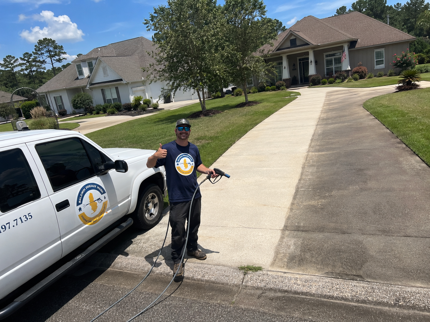 Pressure washing crew rinsing a Mobile Alabama driveway after rust and irrigation stain treatment